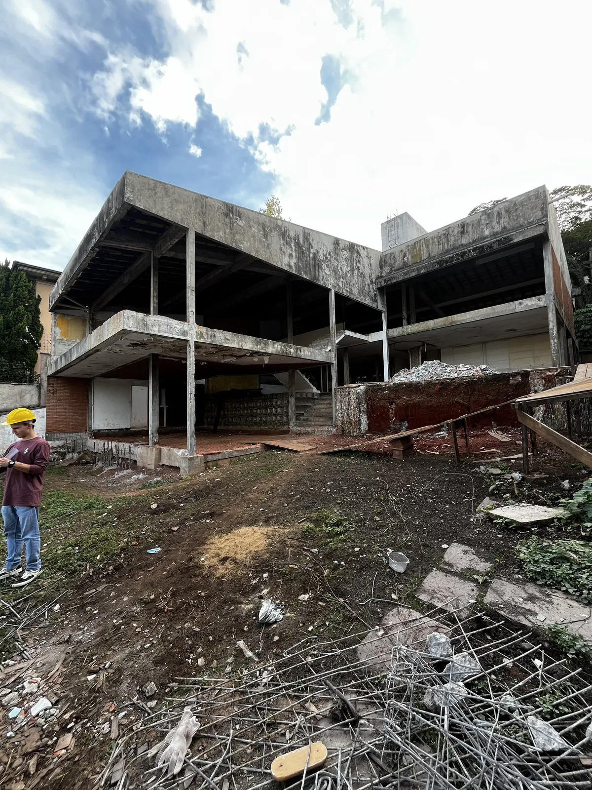 Antes: a casa em obra, só a estrutura de concreto, sem esquadrias, com entulho no terreno.