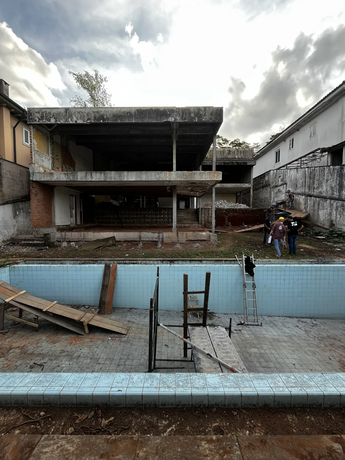 Antes: a fachada dos fundos sem fechamento e a piscina vazia, com escoras.
