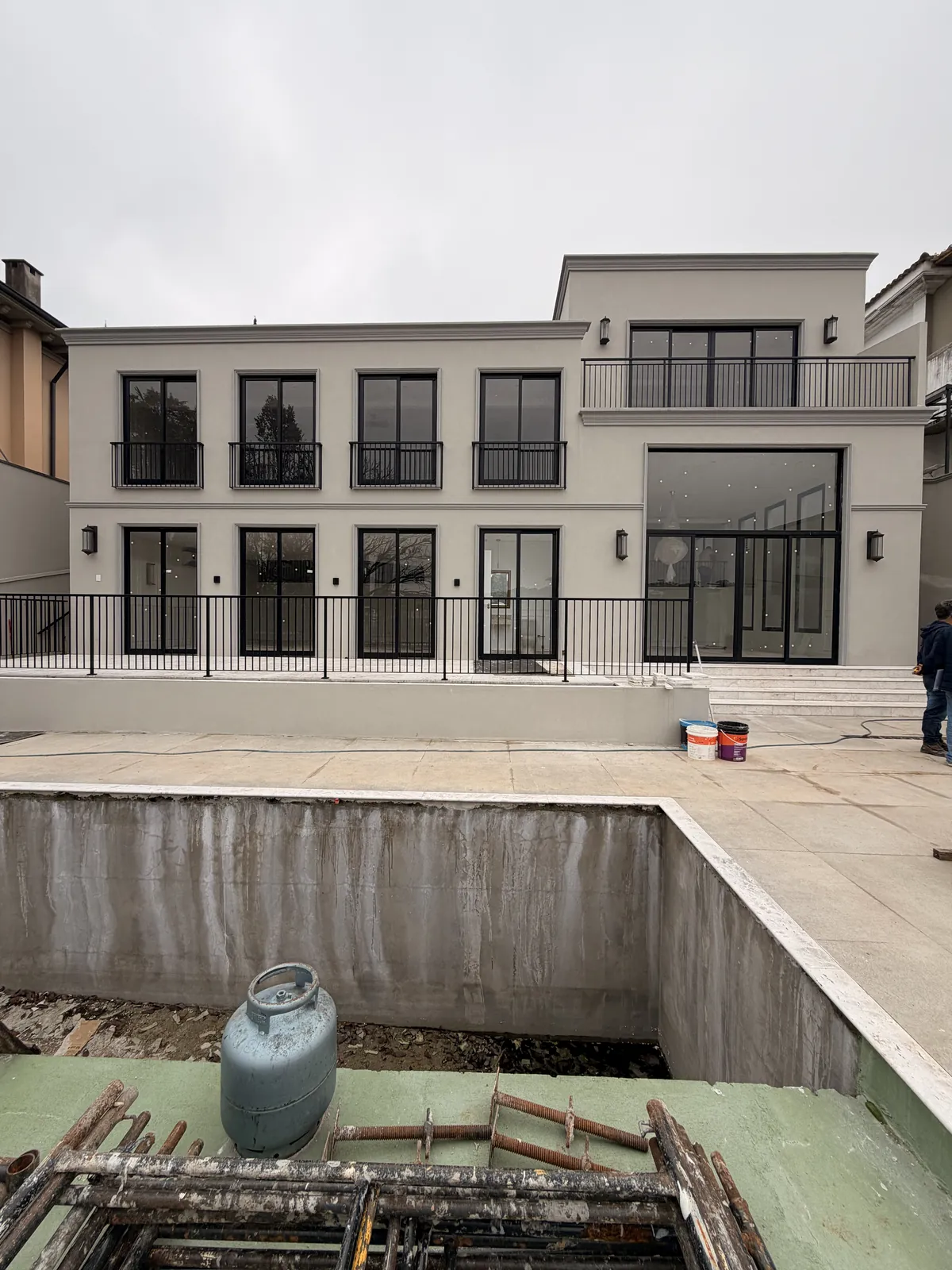Durante: a fachada já com as esquadrias pretas instaladas e a piscina ainda em obra.